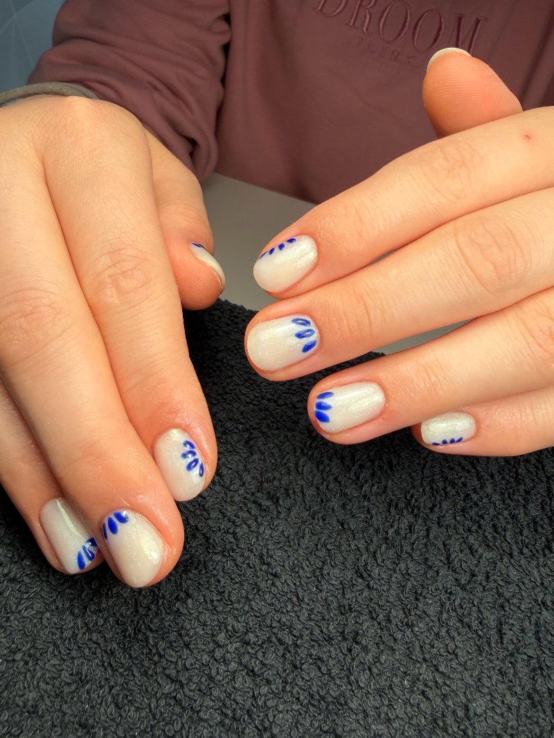 Nude nagels met blauwe bloemblaadjes