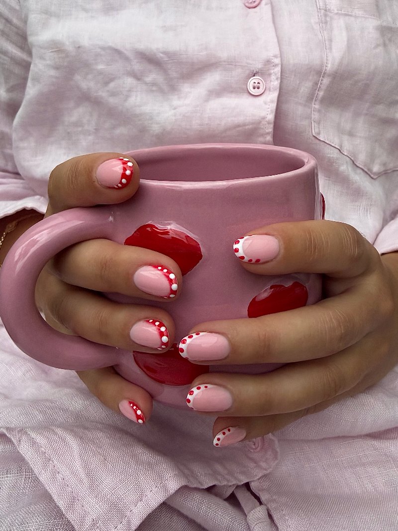 Roze nagels met rode stippen, met een roze mok